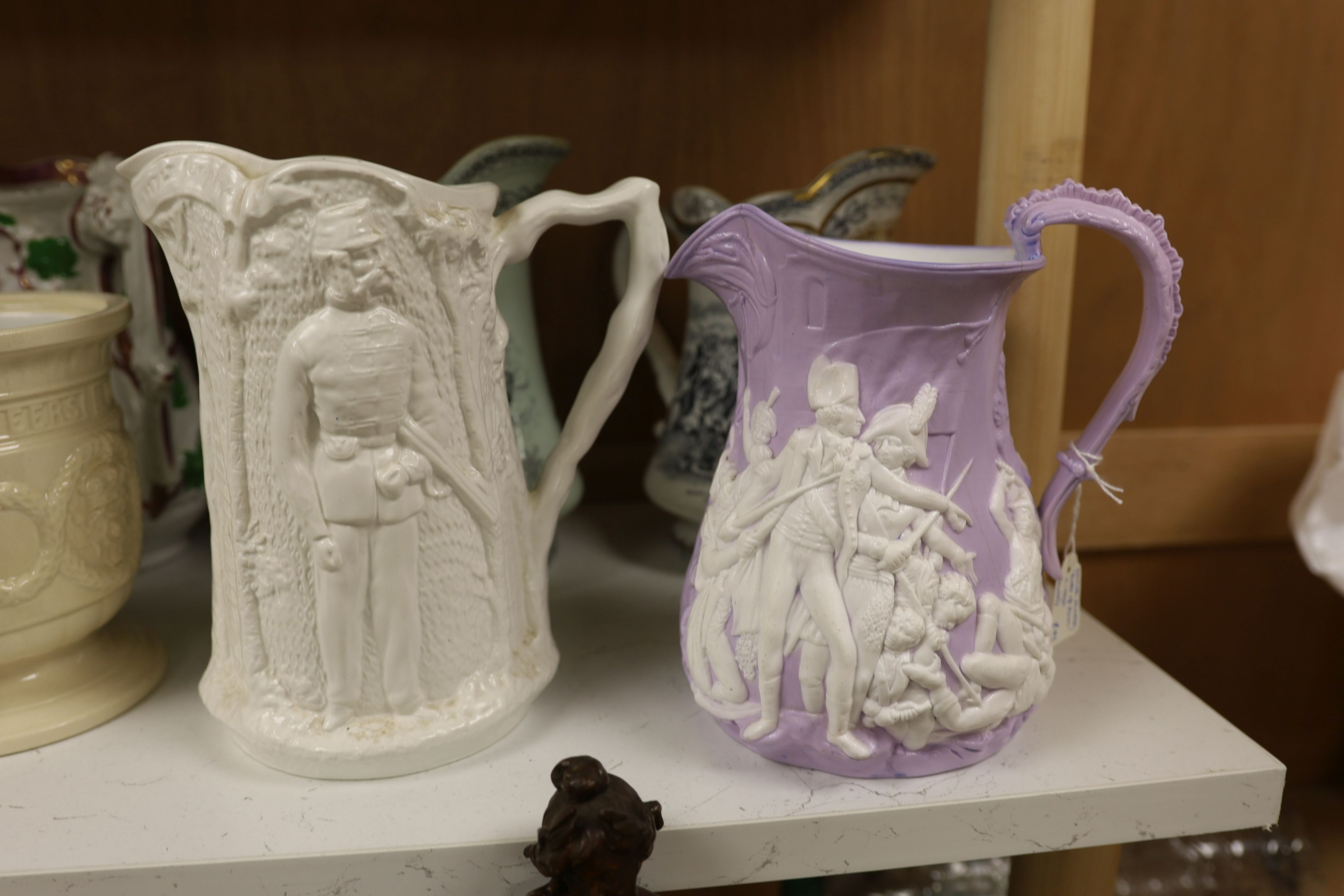 Eight Victorian relief moulded earthenware jugs relating to historic battles and the military